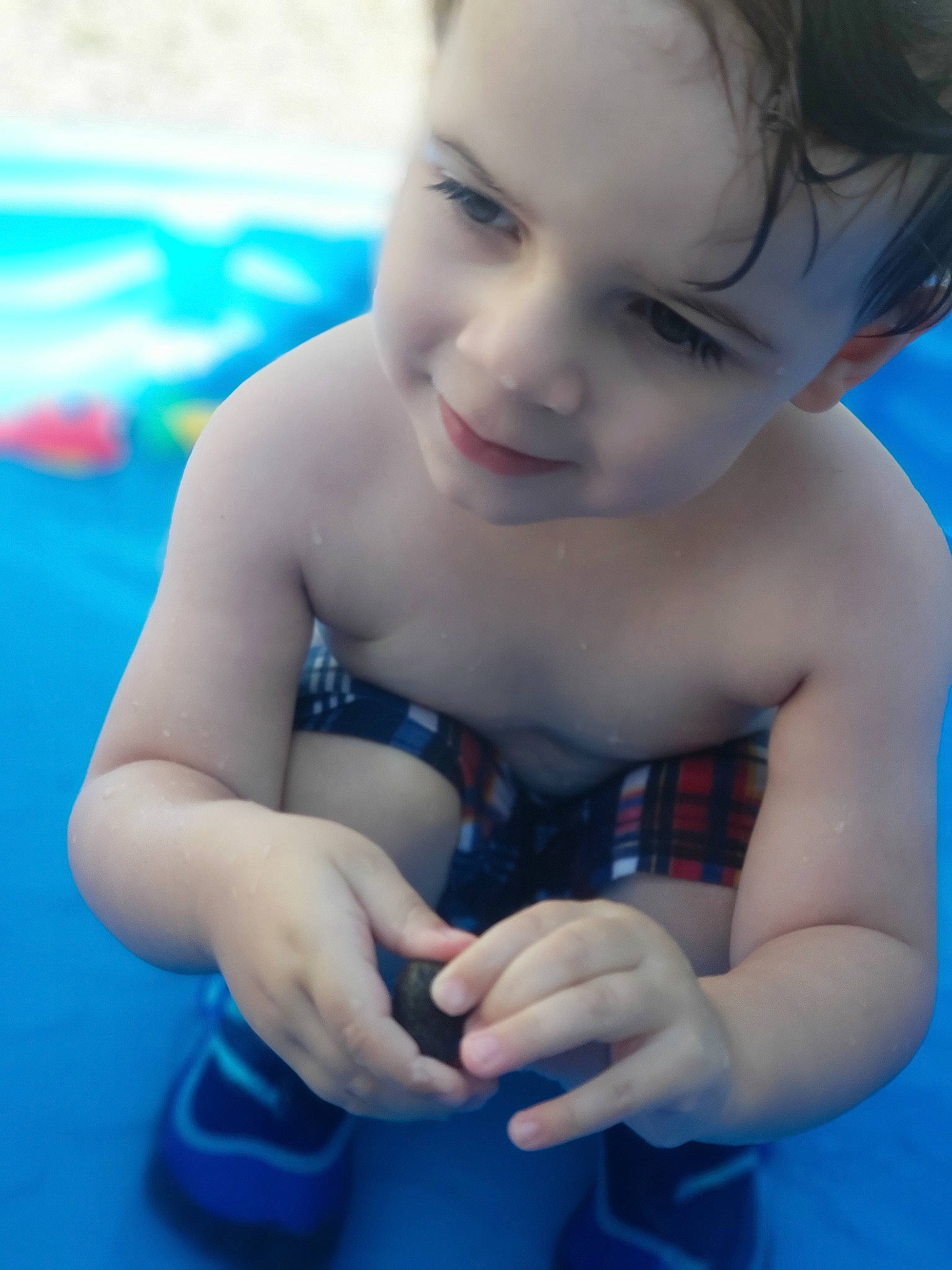 Kayden is registered to the contest to win money with this photo: arm, baby, bathing, blue, cheek, child, eye, face, fun, games, hand, joy, leisure, nose, person, play, pool, skin, summer, swimming_pool