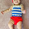 Gwen joined the competition — help win amazing prizes! baby, infant, smile, headband, red, blue, white, striped_clothing, blanket, textured, lying_down, happy, cute, child, skin, arms, legs, indoors, portrait, person
