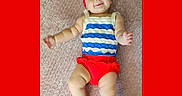Gwen joined the competition — help win amazing prizes! arms, baby, blanket, child, cute, fashion, happy, headband, indoors, infant, legs, lying_down, person, playful, portrait, red_bow, skin, smiling, striped_clothing, toddler