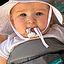 baby, infant, white_hat, sun_hat, hat_string, baby_carrier, infantino_tag, pacifier_string, close_up, portrait, chubby_cheeks, big_eyes, face, skin, clothing, straps, fabric, cute, outdoor, toddler