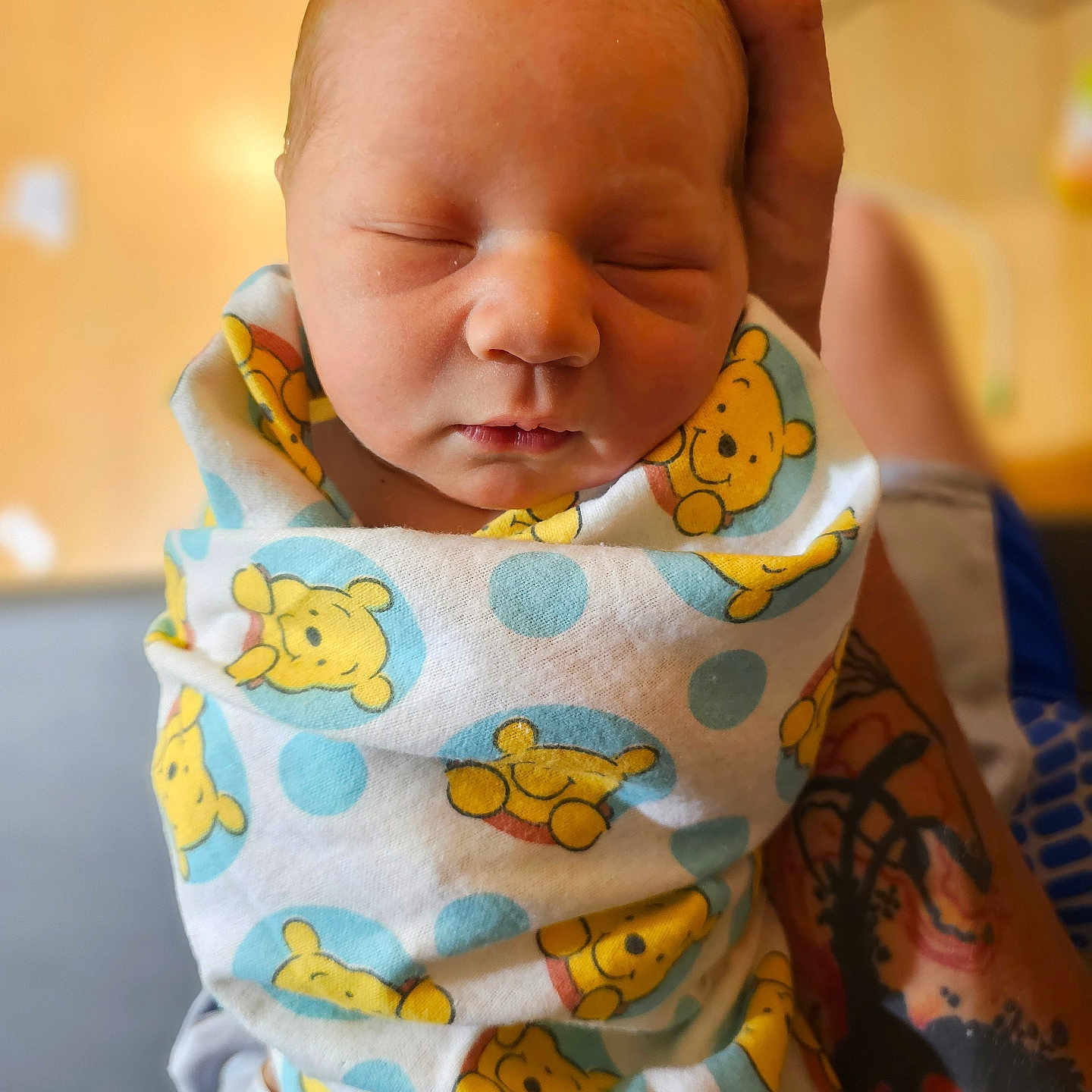 Noah is registered to the contest to win money with this photo: arm, baby, blanket, closeup, comfort, cute, face, indoors, infant, newborn, peaceful, person, portrait, resting, skin, sleeping, soft_light, swaddled, tattoo, winnie_the_pooh