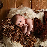 Tiago a rejoint le concours — aidez-le/la à gagner de superbes lots ! baby, blanket, brown, cozy, curly_hair_texture, cute, eyes, face, fur, hand, indoors, infant, lying_down, newborn, portrait, resting, skin, soft_texture, wooden_floor, wrapped