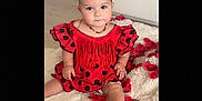 Talya a rejoint le concours — aidez-le/la à gagner de superbes lots ! baby, child, red_dress, headband, bow, polka_dot, fringe, rose_petals, white_rug, indoor, floor, cabinet, shoes, curious, sitting, person, portrait, cute, decor, soft_lighting
