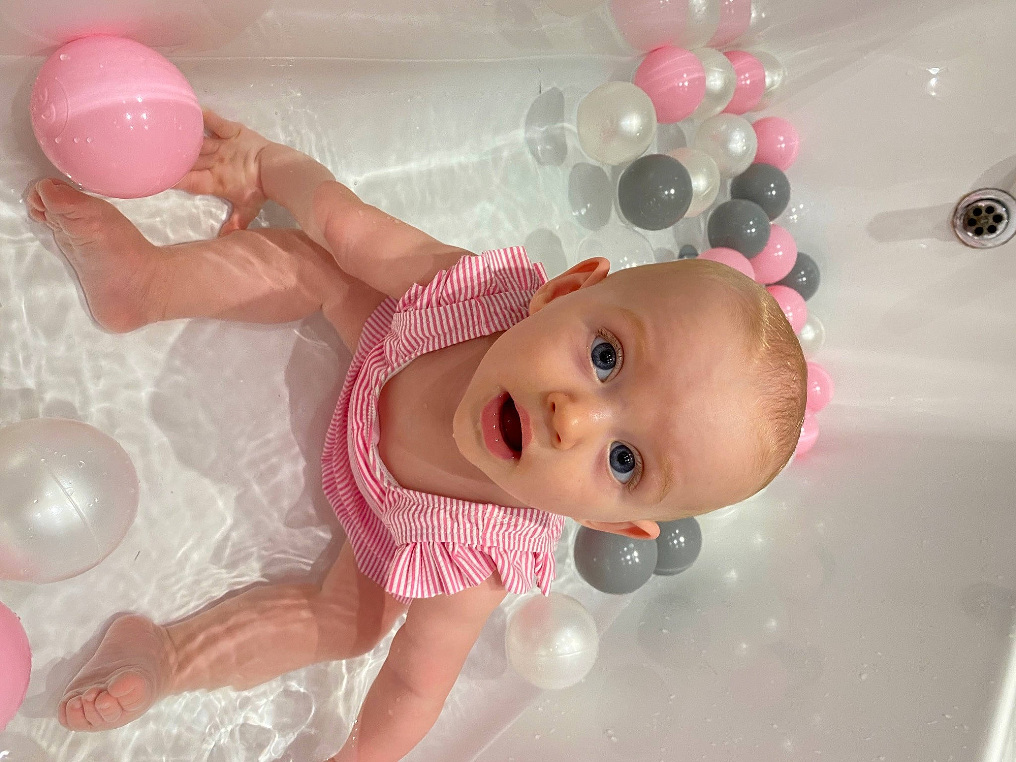 Darcie is registered to the contest to win money with this photo: arm, baby, baby_products, baby_safety, baby_toddler_clothing, balloon, bathing, bathtub, beauty, cheek, child, fun, hand, organ, person, pink, product, room, skin, surprise