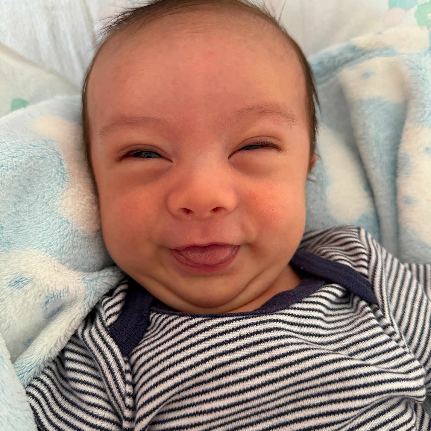 Kye-Hanson joined the competition — help win amazing prizes! baby, blanket, blue_blanket, cheeky, child, closeup, cute, expression, face, happy, head, infant, lying_down, onesie, person, portrait, skin, smile, striped_clothing, tongue