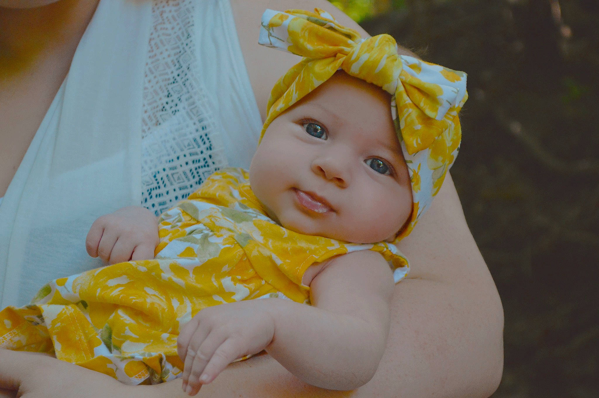 Alyvia is registered to the contest to win money with this photo: baby, baby_toddler_clothing, child, comfort, dress, fashion_accessory, fun, grass, happy, headband, headpiece, headwear, iris, linens, pattern, people_in_nature, person, sitting, skin, textile