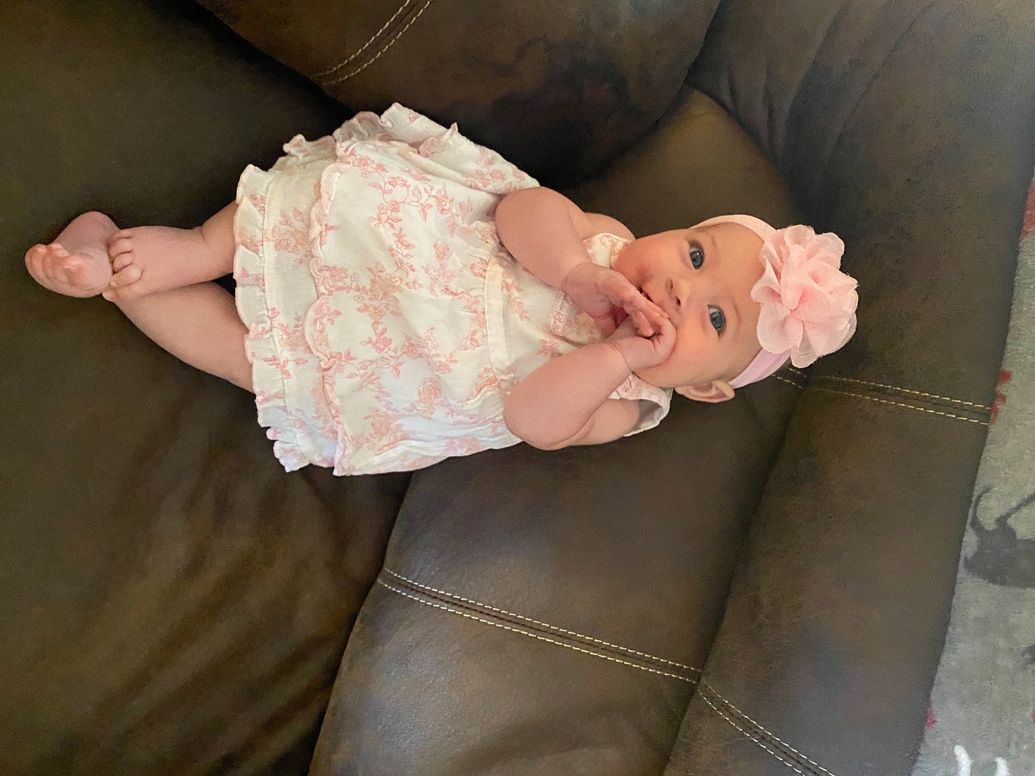 Alyvia is registered to the contest to win money with this photo: arm, baby, baby_toddler_clothing, child, comfort, embellishment, fashion_accessory, hair_accessory, head, headwear, human_body, human_leg, leg, pattern, peach, person, pink, sleeve, textile, thigh