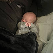 Zayden joined the competition — help win amazing prizes! baby, sleeping, blanket, black_clothing, puma_logo, beard, person, bed, pillow, indoor, cozy, soft_lighting, infant, sleeve, hand, face, resting, warm, comfort, closeup