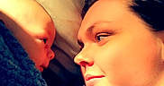 Zayden joined the competition — help win amazing prizes! baby, adult, blanket, bed, face, person, portrait, closeup, gaze, intimacy, love, warmth, cozy, skin, head, comfort, expression, human, indoor, candid