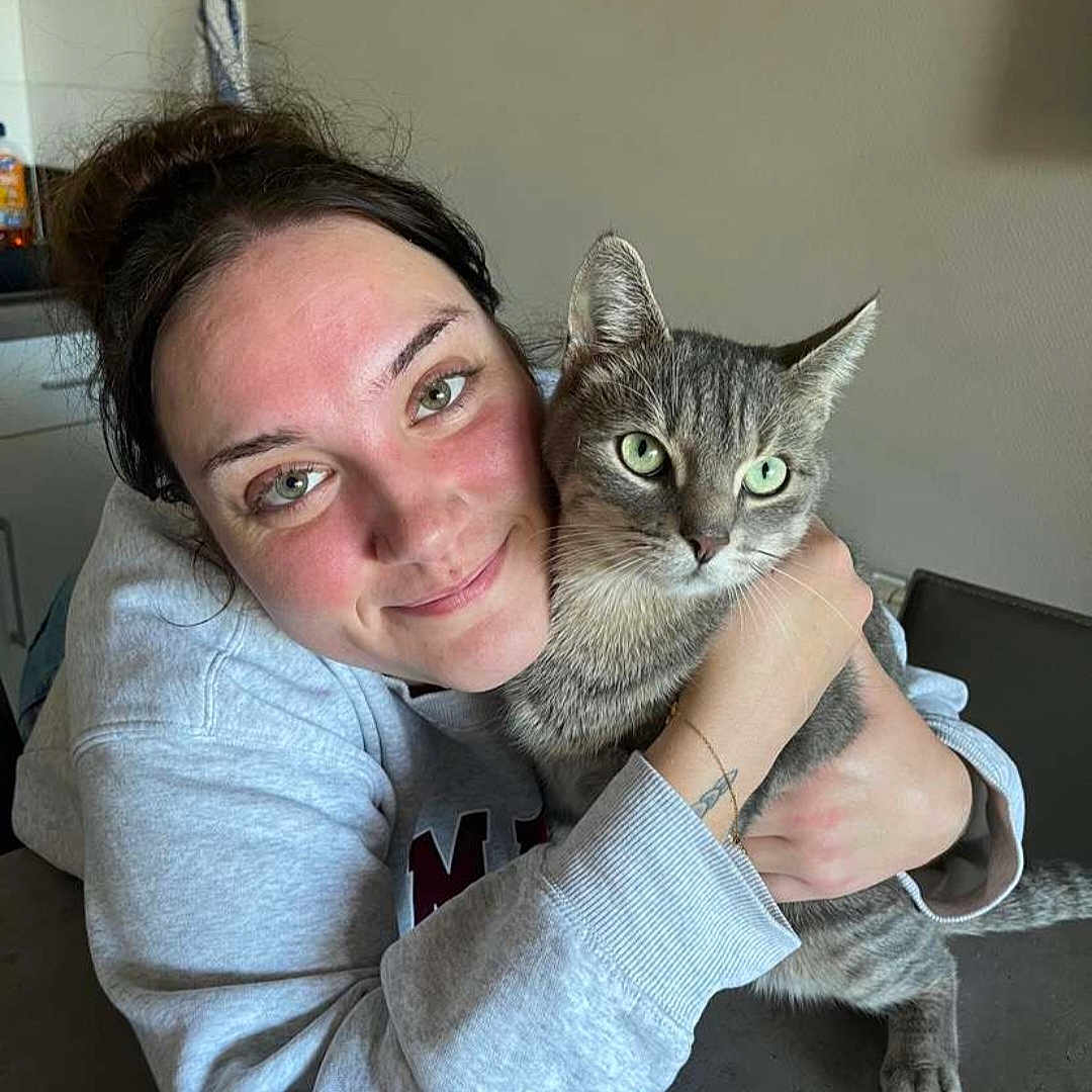 Sprygue participe au concours pour gagner de l'argent avec cette photo : basket, casual_clothing, cat, comfort, face, friendly, gray_cat, green_eyes, home, hug, indoor, kitchen, neutral_wall, pet, portrait, smile, tabby_cat, table, tattoo, woman