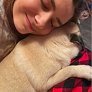 Harley is registered to the contest to win money with this photo: person, dog, snuggling, close_up, cozy, blanket, red_and_black, checkered, fur, sleeping, affection, warmth, indoor, face, smile, comfort, pet, animal, love, relaxation