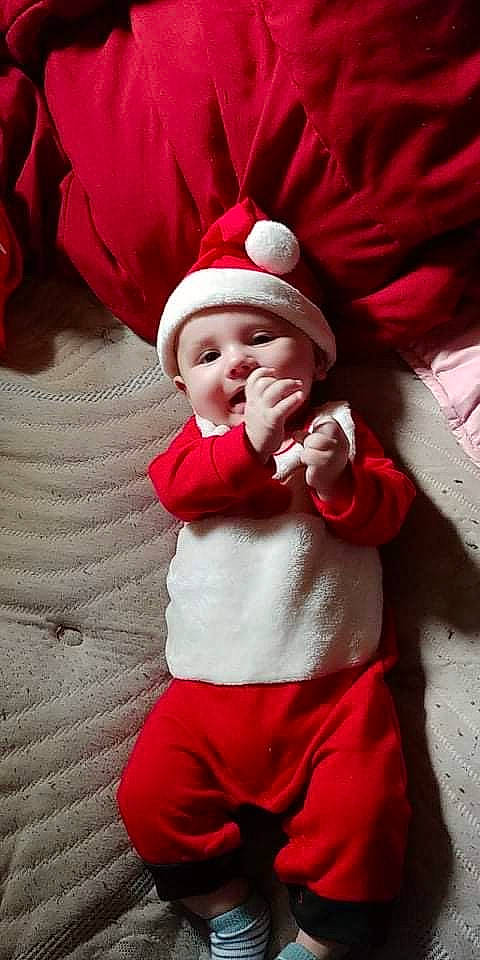 Jarad joined the competition — help win amazing prizes! baby, baby_toddler_clothing, event, face, finger, fun, gesture, happy, hat, headgear, headwear, human_body, person, pink, plant, red, santa_claus, sleeve, smile, toddler