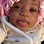 baby, infant, face, pink_bonnet, clothing, onesie, tongue_out, cute, close_up, child, headwear, sleepwear, smiling, portrait, skin, young_child, baby_girl, expression, adorable, playful