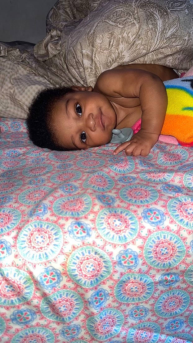 Josiah is registered to the contest to win money with this photo: adaptation, baby, beauty, child, comfort, crawling, floor, flooring, fun, happy, hardwood, linens, mouth, nose, pattern, person, skin, smile, textile, toddler