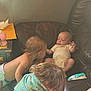 Keifton is registered to the contest to win money with this photo: baby, toddler, child, infant, couch, leather_couch, onesie, towel, bottle, furniture, indoor, curly_hair, diaper, table, curious, family, household_items, skin, hair, casual