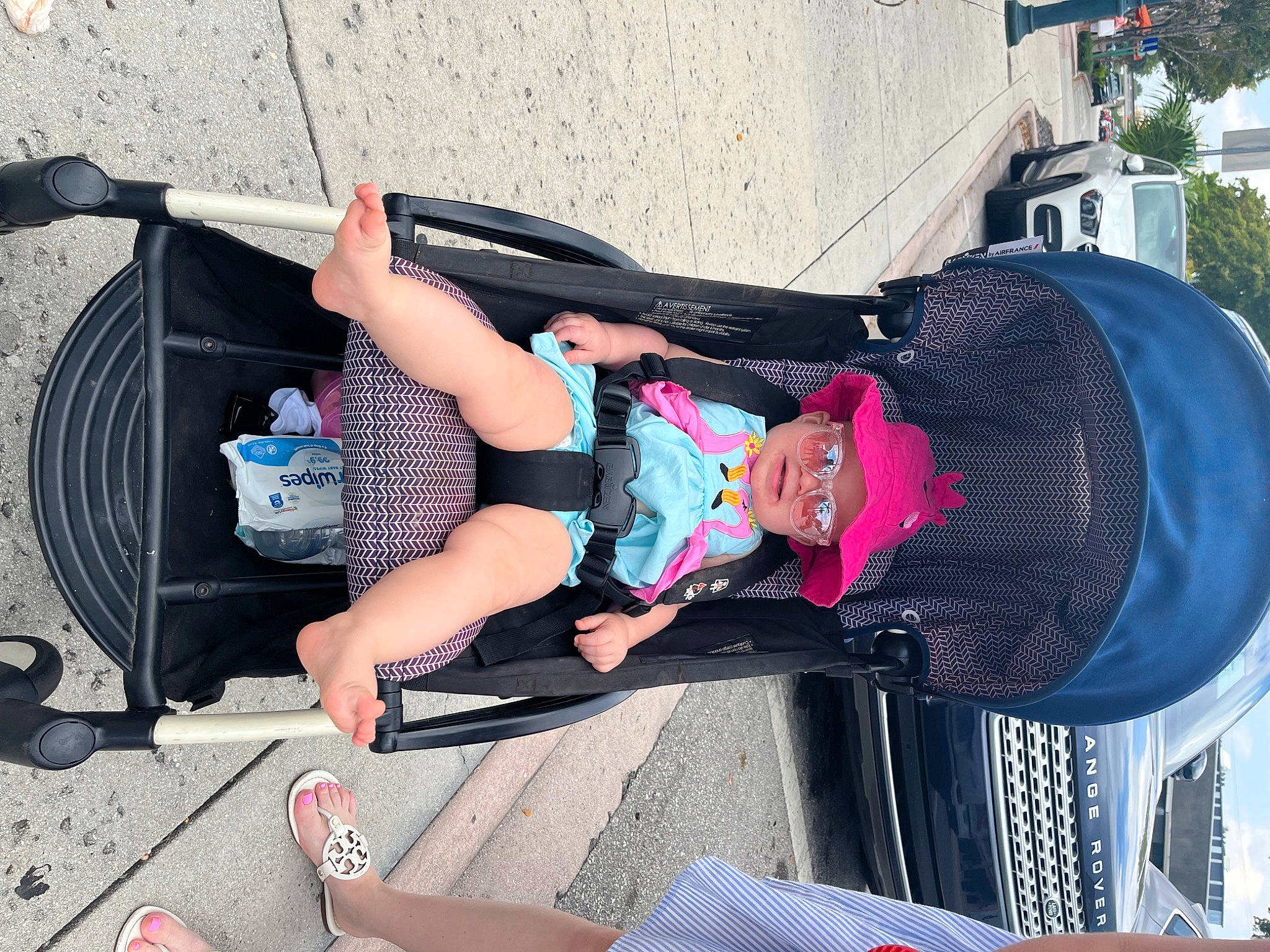 Bree is registered to the contest to win money with this photo: bumper, electric_blue, foot, fun, hat, headwear, human_leg, knee, lap, leisure, magenta, person, plant, shoe, shorts, smile, sneakers, thigh, toddler, travel