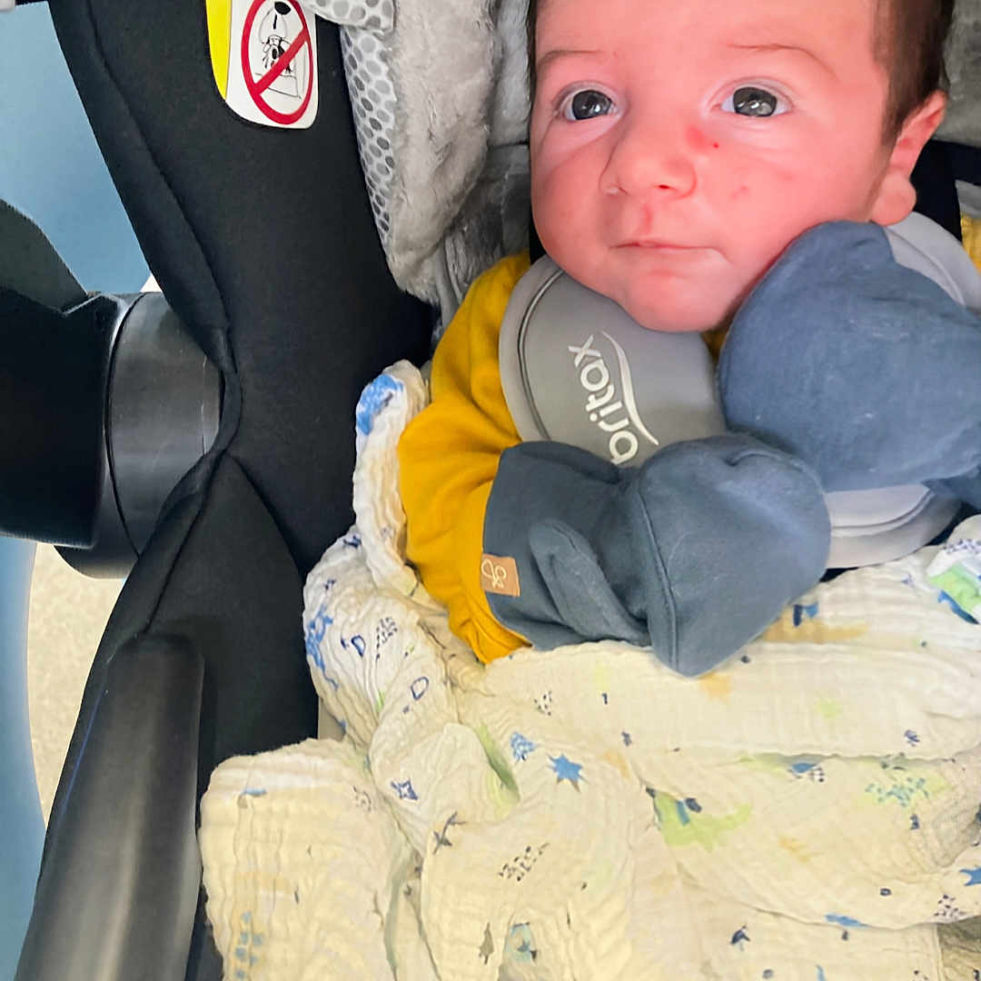 Ramneek is registered to the contest to win money with this photo: baby, bodypart, car, car_interior, carseat, clothing, cushion, face, finger, glove, hand, head, headrest, homedecor, newborn, person, photography, portrait, transportation, vehicle