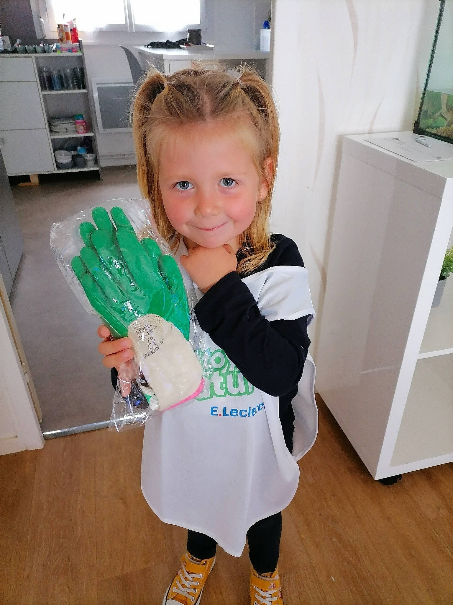 Méline participe au concours pour gagner de l'argent avec cette photo : baby_toddler_clothing, child, floor, flooring, fun, happy, hardwood, human_leg, joy, kitchen_appliance, knee, person, room, shelf, sleeve, smile, sock, standing, t_shirt, thumb