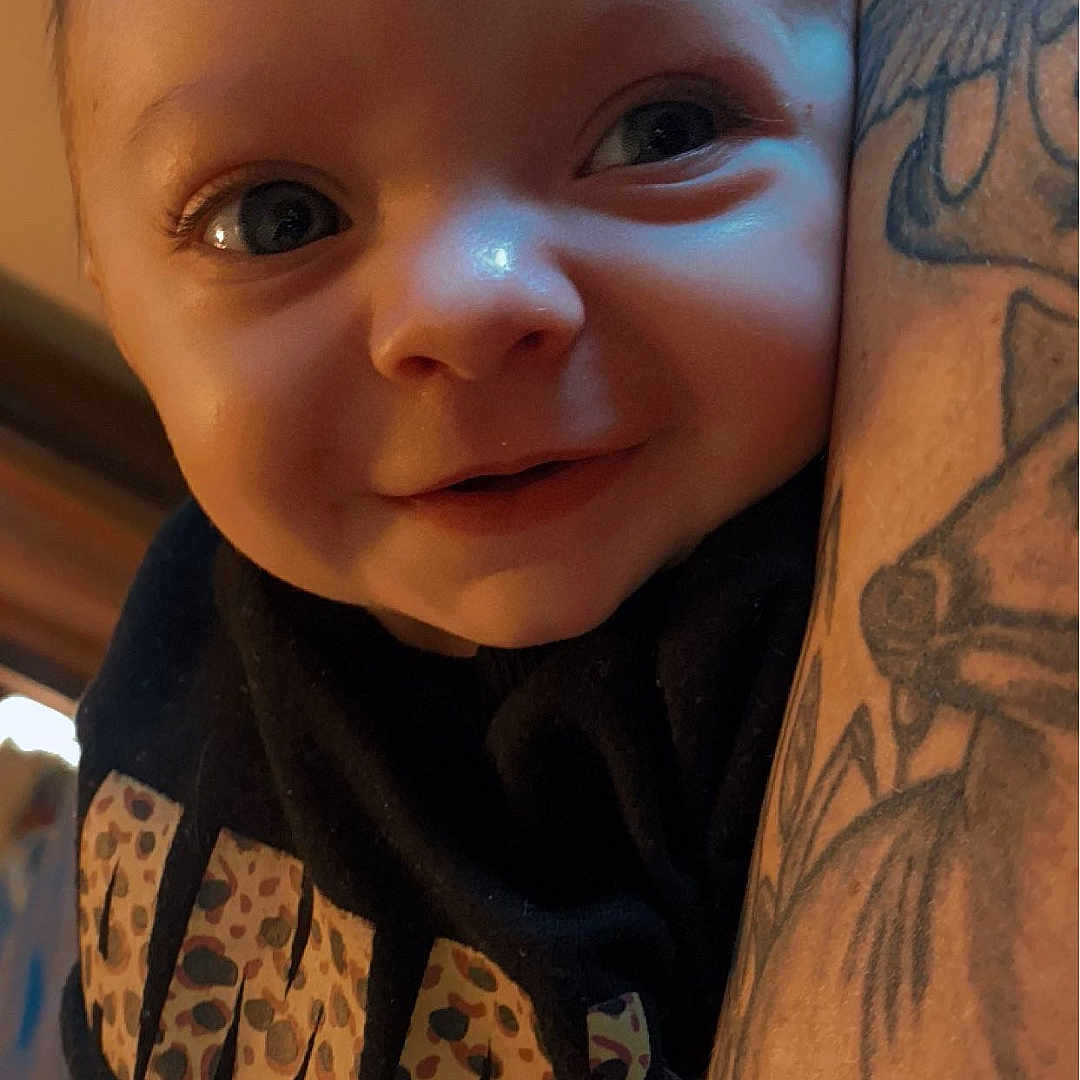 Adalyn is registered to the contest to win money with this photo: arm, baby, bodypart, clothing, face, finger, hand, happy, head, mouth, newborn, person, photography, portrait, selfie, skin, smile, t_shirt, tattoo, teeth