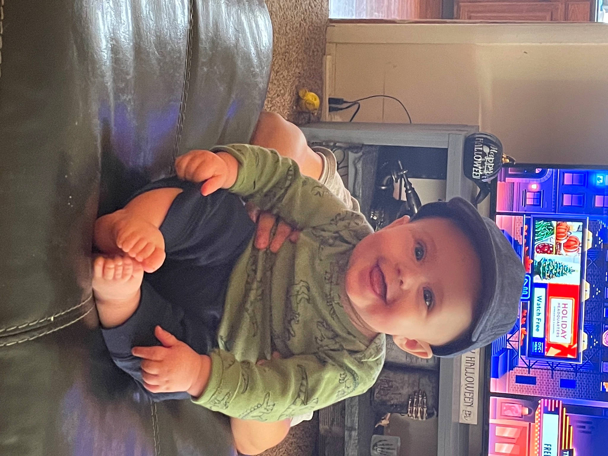 Ryatt is registered to the contest to win money with this photo: baby, baby_toddler_clothing, child, comfort, curtain, elbow, fun, gesture, happy, headwear, joy, machine, person, play, room, shelf, sitting, smile, t_shirt, thumb