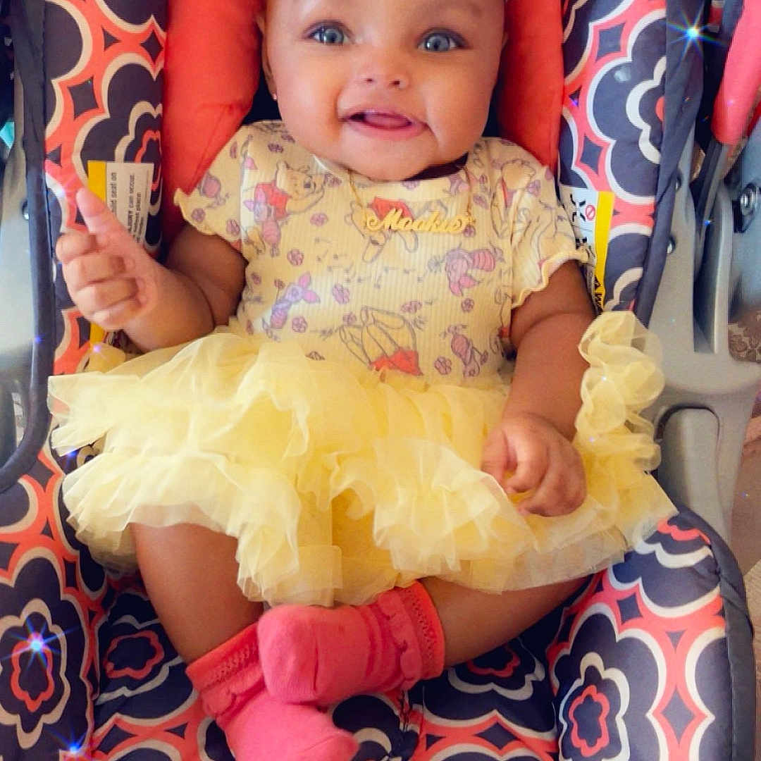 Evver is registered to the contest to win money with this photo: accessory, adorable, baby, baby_girl, car_seat, child, cloth, cute, fashion, happy, headband, indoors, infant, patterned_fabric, pink_socks, portrait, seated, small_child, smiling, yellow_tutu