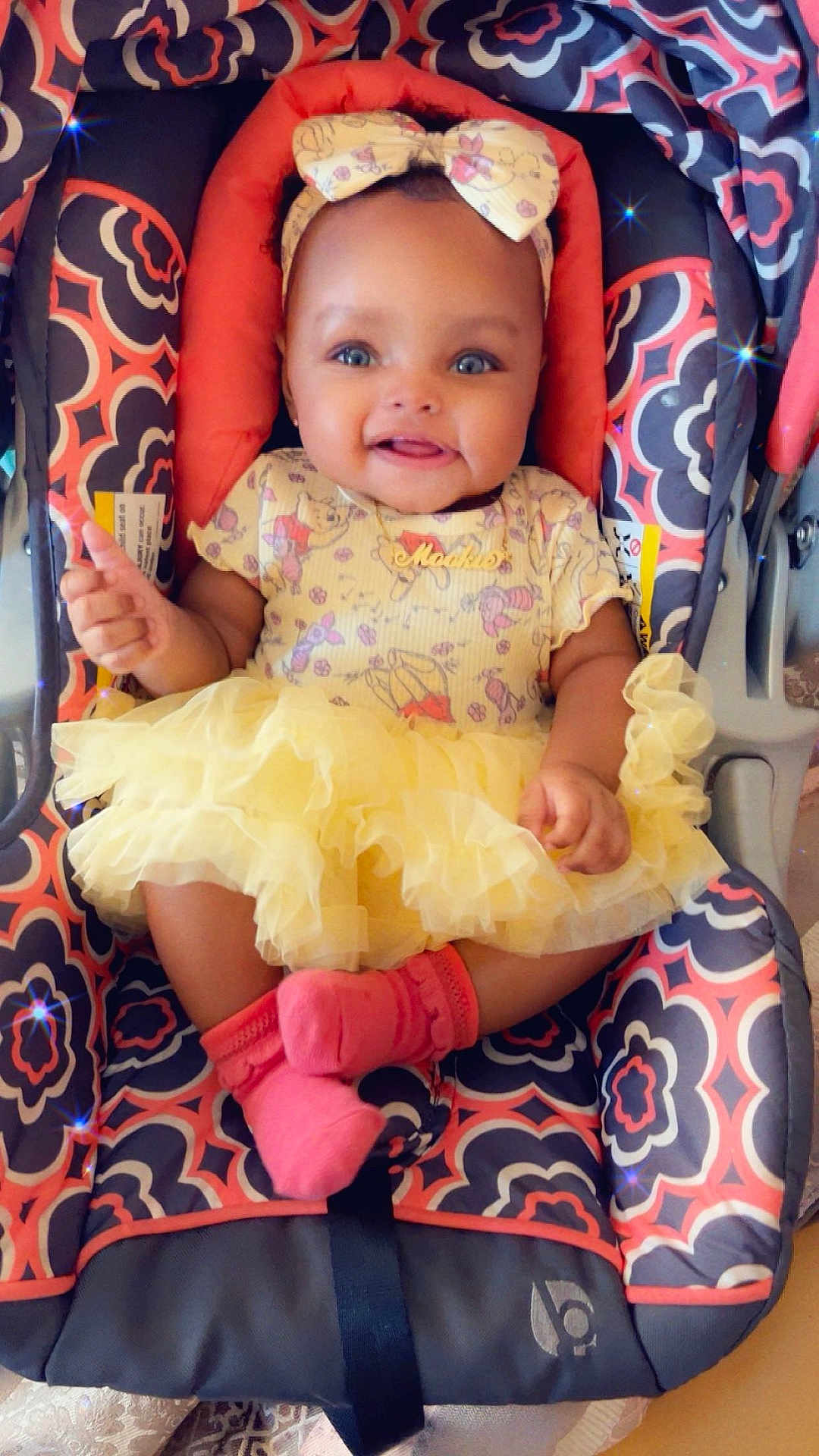 Evver is registered to the contest to win money with this photo: baby, infant, smiling, yellow_tutu, headband, car_seat, pink_socks, patterned_fabric, cute, happy, child, portrait, indoors, seated, adorable, cloth, baby_girl, fashion, accessory, small_child