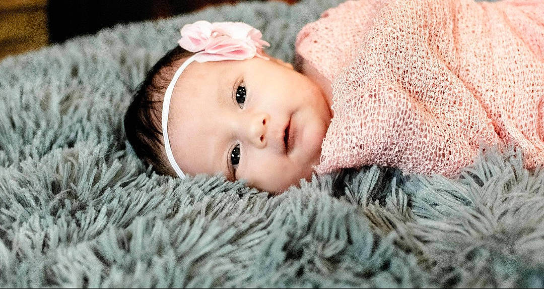 Ariah is registered to the contest to win money with this photo: art, baby, baby_toddler_clothing, cap, cheek, eye, eyelash, grass, hat, head, headgear, iris, knit_cap, lip, person, pink, skin, textile, toddler, wood