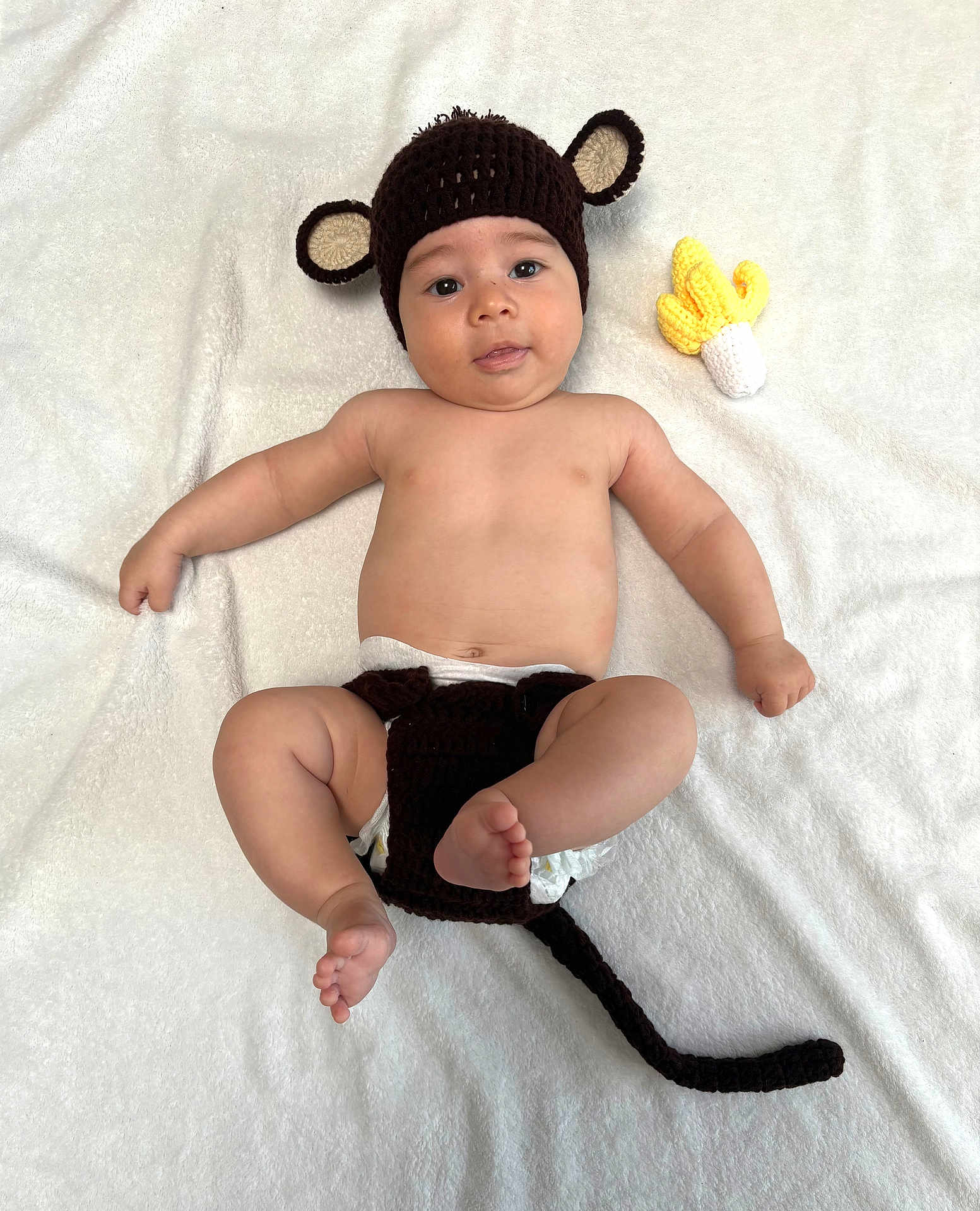 Yzac participe au concours pour gagner de l'argent avec cette photo : baby, infant, cute, monkey_hat, crocheted, diaper, toy, banana, soft_blanket, lying_down, smiling, chubby_cheeks, bare_chest, playful, child, indoors, infant_clothing, headwear, toddler, adorable
