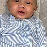 Anthony Jr. is registered to the contest to win money with this photo: baby, child, smiling, face, head, onesie, striped_clothing, cushion, seat, indoor, portrait, happy, cute, infant, young_child, skin, person, closeup, babywear, comfortable