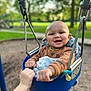 Anthony Jr. is registered to the contest to win money with this photo: baby, swing, playground, smiling, child, hand, outdoor, park, trees, grass, metal, blue, clothing, blanket, happy, person, seat, nature, fun, daytime
