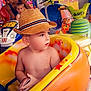 amusement_ride, bright_colors, casual, child, colorful, daytime, face, family, fun, hat, hat_band, indoor, looking_away, person, playground, short_hair, summer, toddler, toy_car, woman