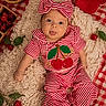 Ruxen is registered to the contest to win money with this photo: baby, infant, child, striped_clothing, headband, bow, red_and_white, blanket, knitted, cherries, fruit, checkered_pattern, cute, playful, tongue_out, indoors, portrait, smiling, happy, cozy