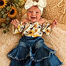 baby, child, smiling, headband, bow, sunflower, flower, denim, pants, top, sitting, happy, cute, indoor, cushion, rug, portrait, person, plant, cozy