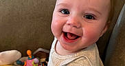 Skyler joined the competition — help win amazing prizes! baby, child, smile, happy, cute, face, indoors, toy, plush_toy, couch, clothing, person, infant, sitting, bright_eyes, cheerful, home, young_child, playtime, cozy
