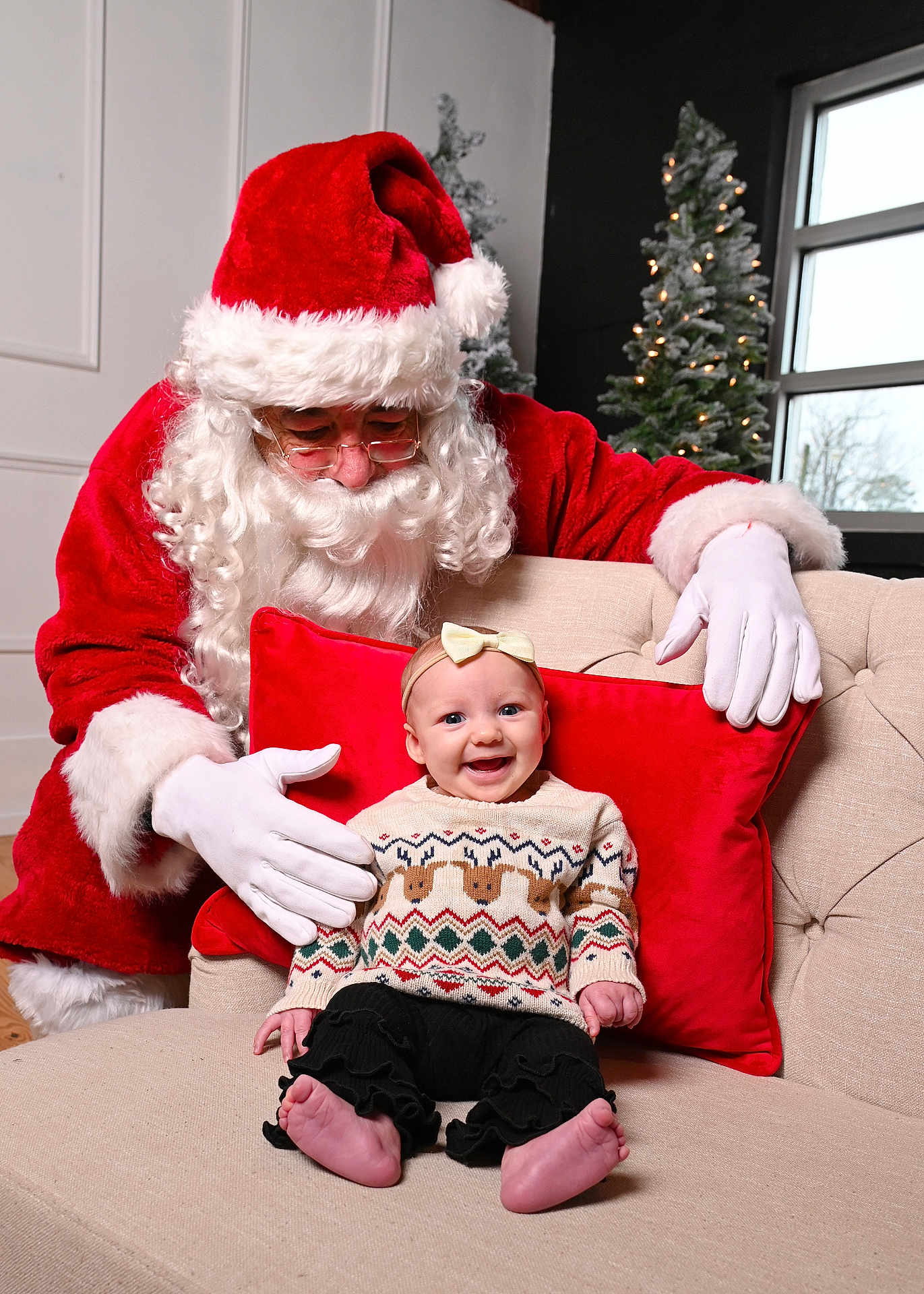 Sutton joined the competition — help win amazing prizes! baby, child, santa_claus, christmas, holiday, smiling, sweater, red_pillow, couch, indoor, festive, glasses, white_gloves, beard, window, decorated_tree, happy, portrait, headband, cute