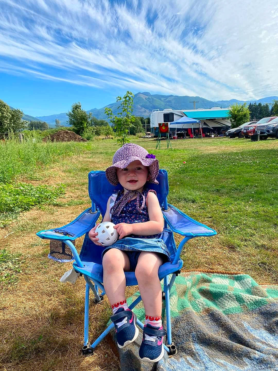 Brixley joined the competition — help win amazing prizes! cloud, electric_blue, grass, grassland, hat, headwear, knee, landscape, leisure, meadow, outdoor_furniture, people_in_nature, person, plant, recreation, shorts, sky, sun_hat, thigh, toddler