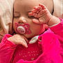 baby, sleeping, pacifier, pink_clothing, blanket, hand, face, infant, cute, peaceful, soft_lighting, closeup, cozy, indoors, child, newborn, rest, portrait, warm_colors, toddler