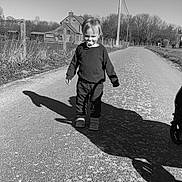 Esteban a rejoint le concours — aidez-le/la à gagner de superbes lots ! child, pacifier, shadow, road, rural, outdoor, trees, house, daylight, monochrome, black_and_white, clothing, footwear, sky, pole, fence, nature, person, walking, sunlight