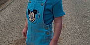 Esteban a rejoint le concours — aidez-le/la à gagner de superbes lots ! toddler, child, smile, overalls, mickey_mouse, blue_shirt, sneakers, road, outdoor, sidewalk, grass, buildings, daylight, funny_expression, person, casual_clothing, cute, young_child, standing, playful