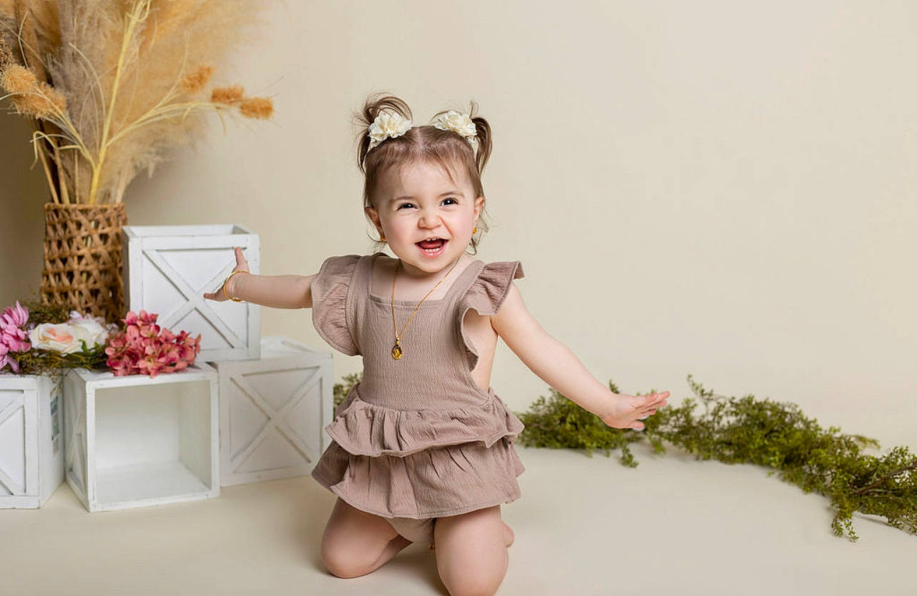 Alianna joined the competition — help win amazing prizes! baby, baby_toddler_clothing, child, day_dress, embellishment, event, fashion_accessory, fashion_design, happy, headpiece, human_leg, pattern, peach, person, plant, ruffle, sitting, sleeve, smile, toddler