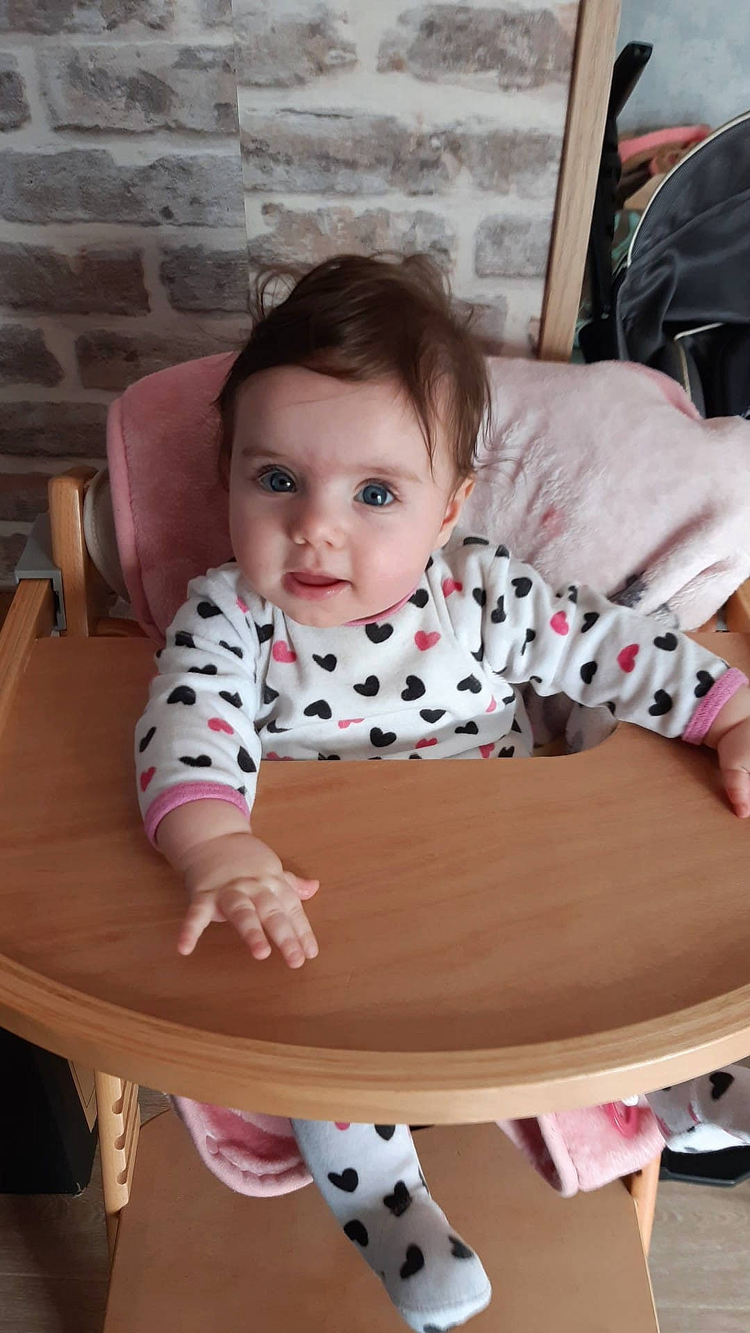 Talia participe au concours pour gagner de l'argent avec cette photo : baby, baby_products, baby_toddler_clothing, bib, chair, cheek, child, comfort, flooring, hairstyle, hardwood, head, human, person, sitting, skin, sleeve, t_shirt, table, toddler