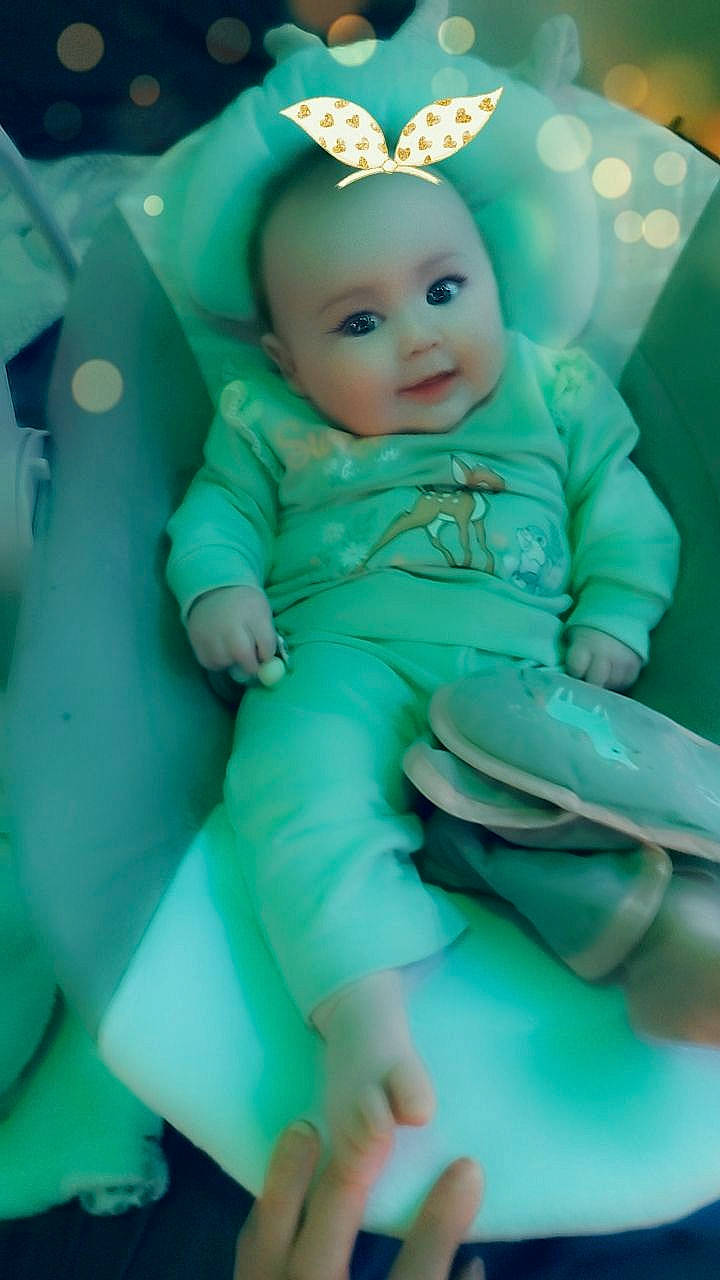 Riley joined the competition — help win amazing prizes! aqua, baby, baby_products, baby_toddler_clothing, cheek, child, comfort, face, fashion_accessory, fun, green, happy, headpiece, person, room, sitting, smile, sock, thumb, toddler