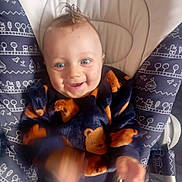 Lyssandro participe au concours pour gagner de l'argent avec cette photo : baby, baby_seat, bear_pattern, blue_eyes, child, clothing, cozy, cute, face, hair, hand_motion, happy, indoors, infant, patterned, portrait, seat, smiling, soft_fabric, sweater