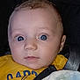 baby, baby_clothes, blue_eyes, car_seat, child, close_up, clothing, curious, expression, face, head, indoor, infant, looking, person, portrait, seatbelt, skin, yellow_shirt, young