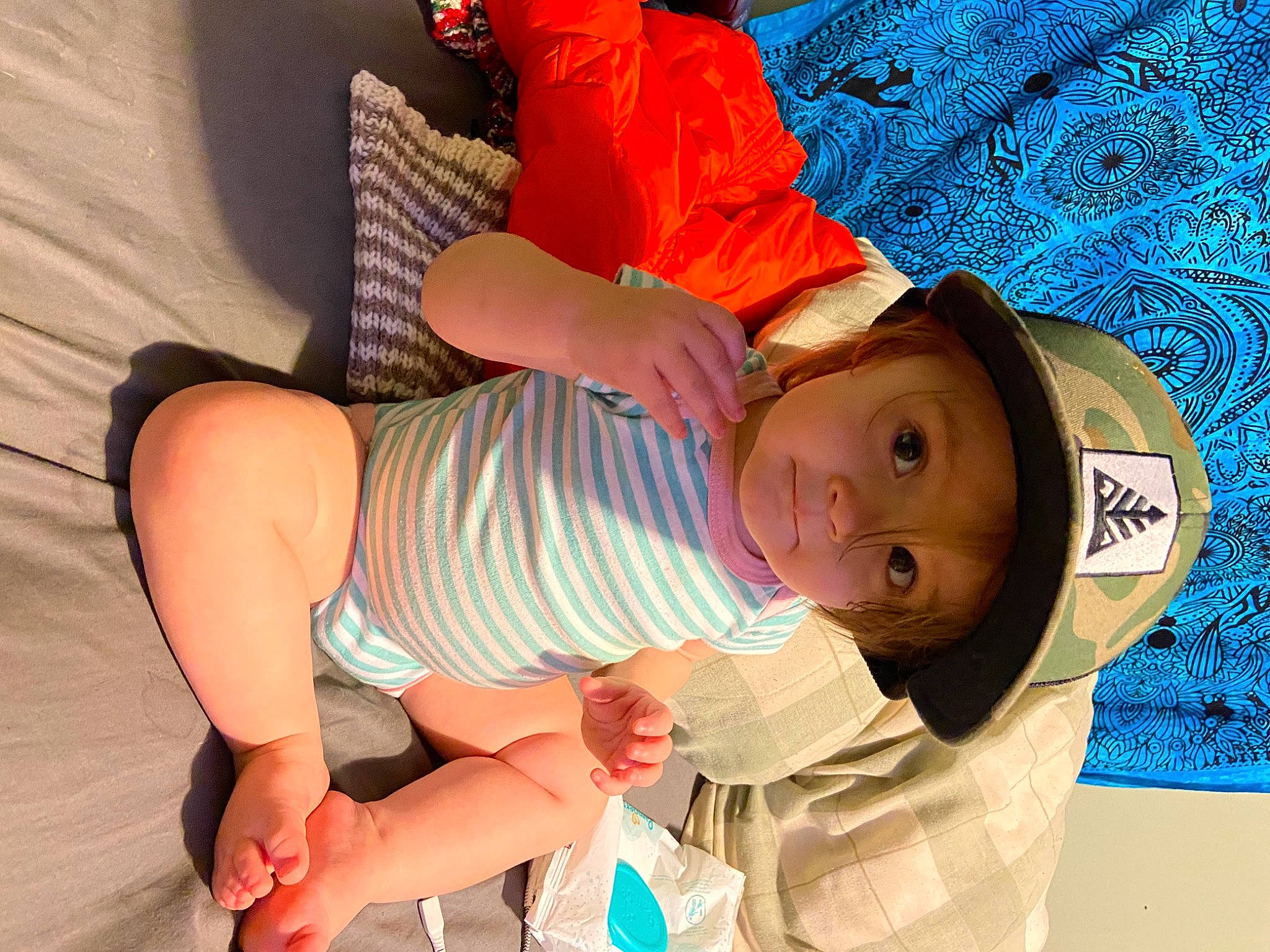 Averie is registered to the contest to win money with this photo: arm, baby, blue, comfort, facial_expression, finger, glasses, hand, happy, headwear, joint, knee, leg, mouth, orange, person, shorts, shoulder, skin, stomach