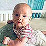 baby, infant, child, striped_shirt, pillow, bedroom, crib, curtains, blue_eyes, cute, expression, furniture, person, laying, soft_lighting, indoor, cushion, white, red, comfort