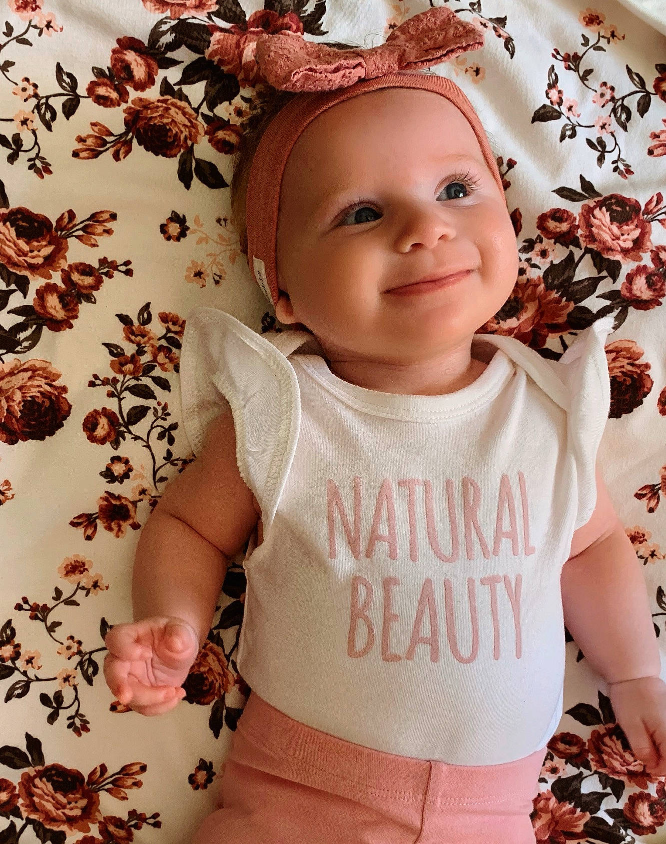 Lani is registered to the contest to win money with this photo: baby, baby_products, baby_toddler_clothing, brown_hair, cheek, child, clothing, fashion_accessory, fawn, hair_accessory, headband, headgear, headwear, joy, pattern, peach, person, pink, product, sleeve