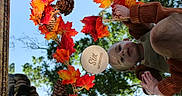 Asher is registered to the contest to win money with this photo: autumn, baby, blue_sky, child, cozy_clothing, fall, infant, maple_leaves, milestone_photo, nature, orange_leaves, outdoor, pinecones, portrait, red_leaves, reflection, six_months, sweater, trees, wooden_plaque