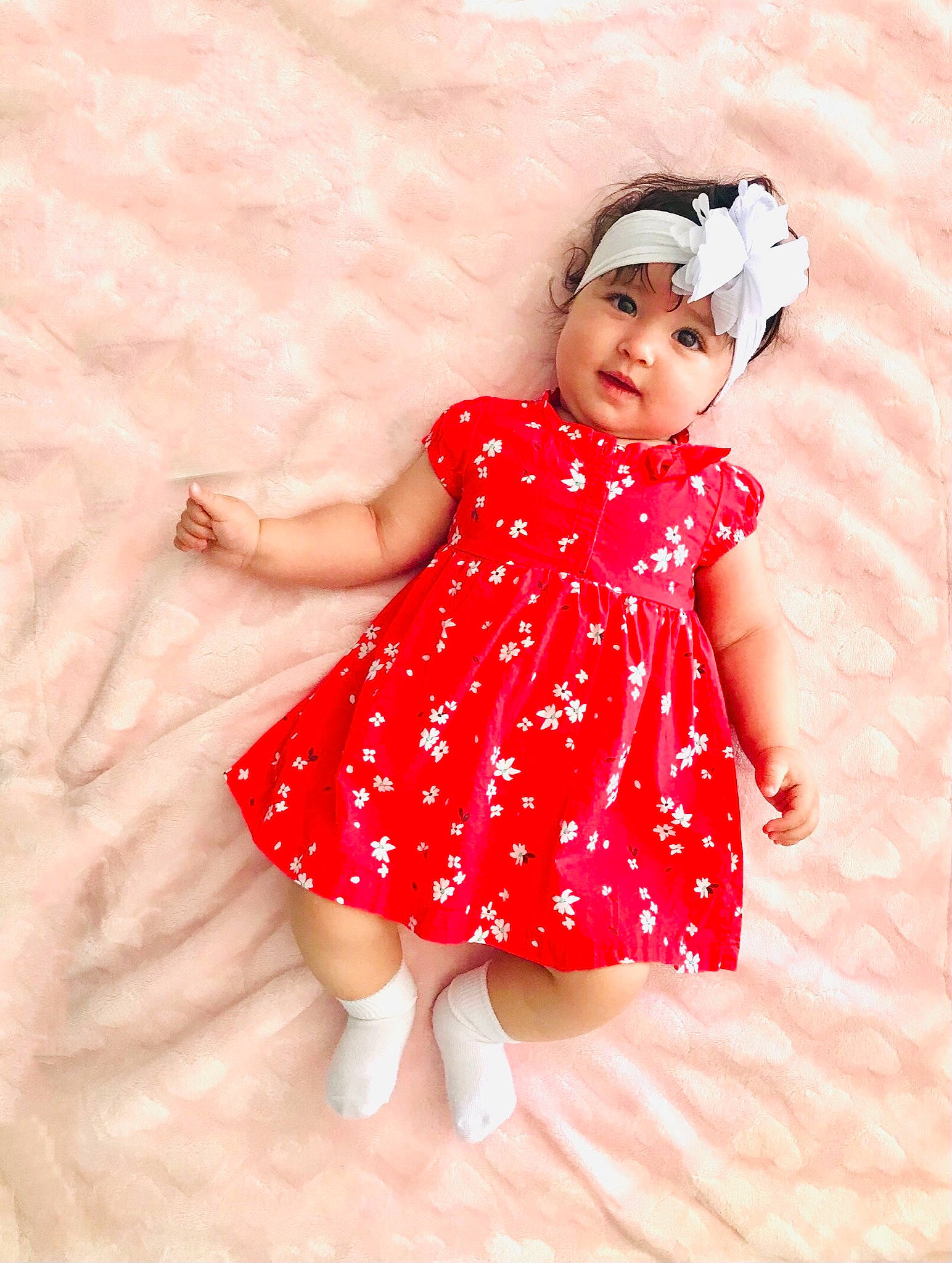 Isabella is registered to the contest to win money with this photo: arm, baby_toddler_clothing, child, clothing, day_dress, dress, finger, fun, gesture, happy, headwear, human_leg, magenta, one_piece_garment, pattern, person, pink, skin, sleeve, textile