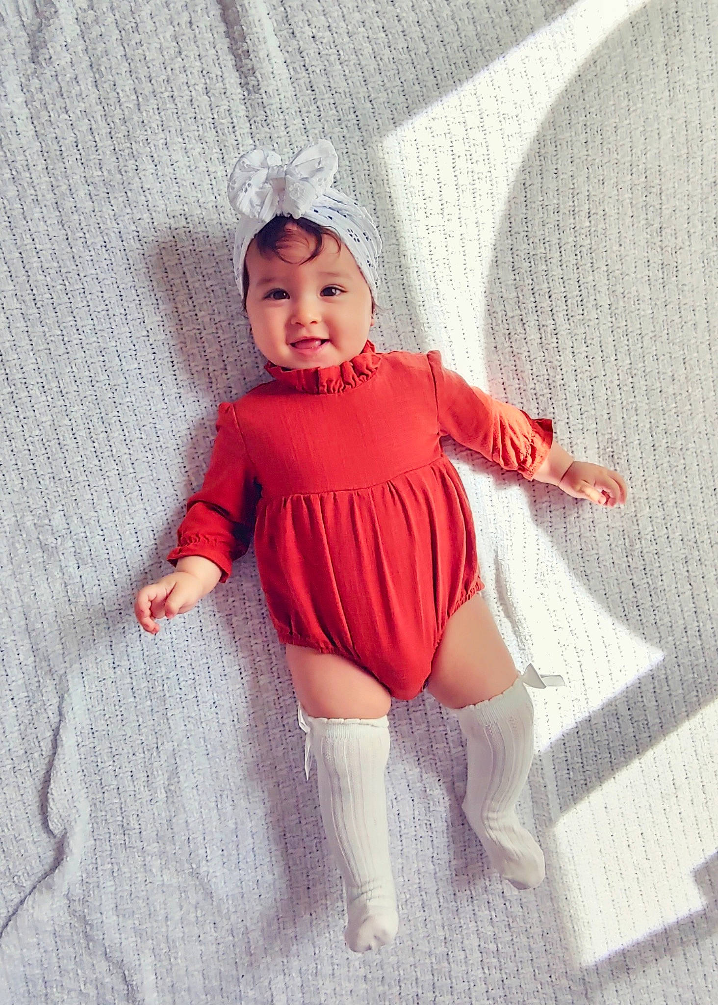 Isabella is registered to the contest to win money with this photo: baby_toddler_clothing, day_dress, face, fashion_design, flooring, head, headwear, human_body, human_leg, knee, lip, neck, pattern, person, sleeve, sock, sportswear, t_shirt, thigh, toddler